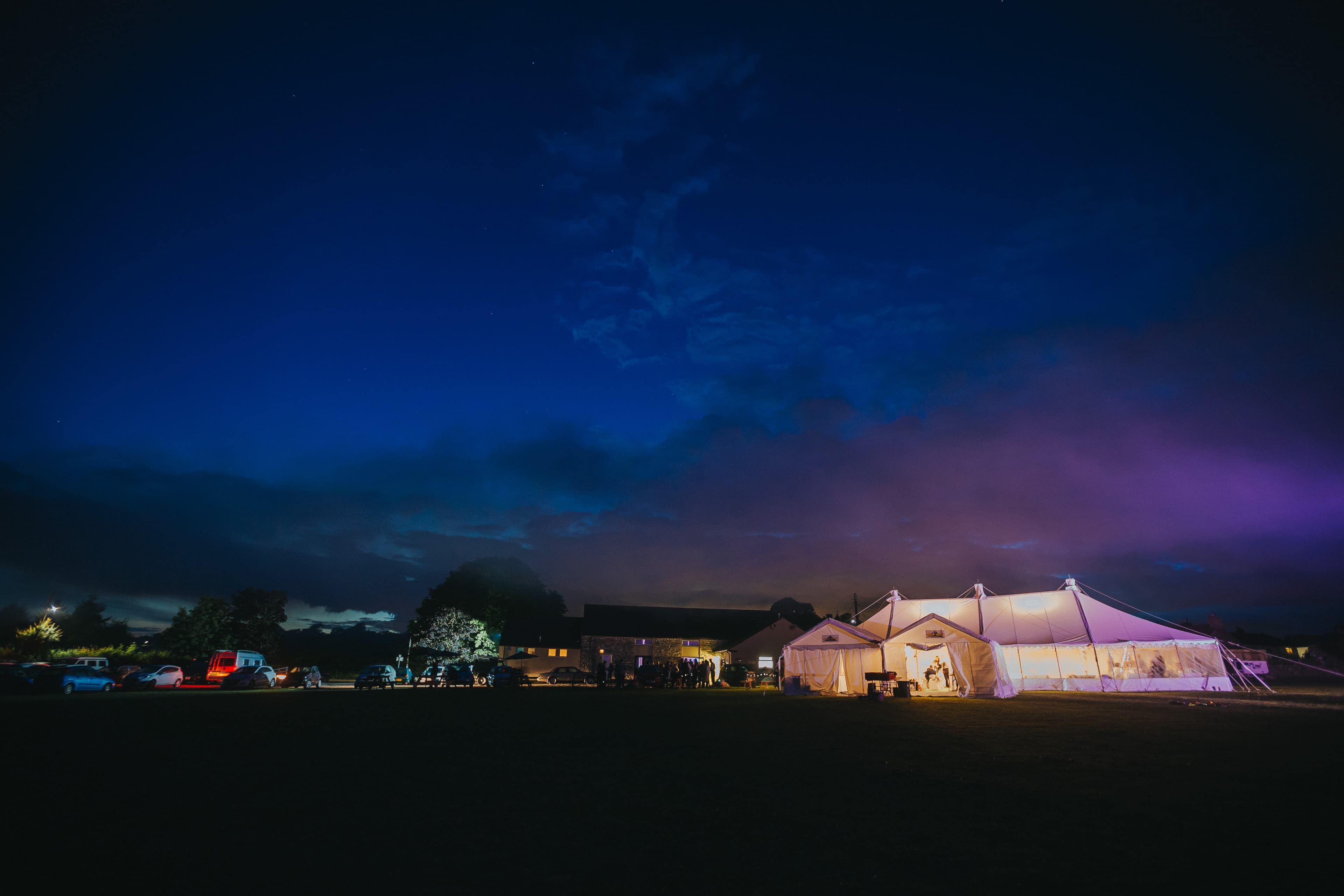 The hall's field at twilight with a lit marquee event